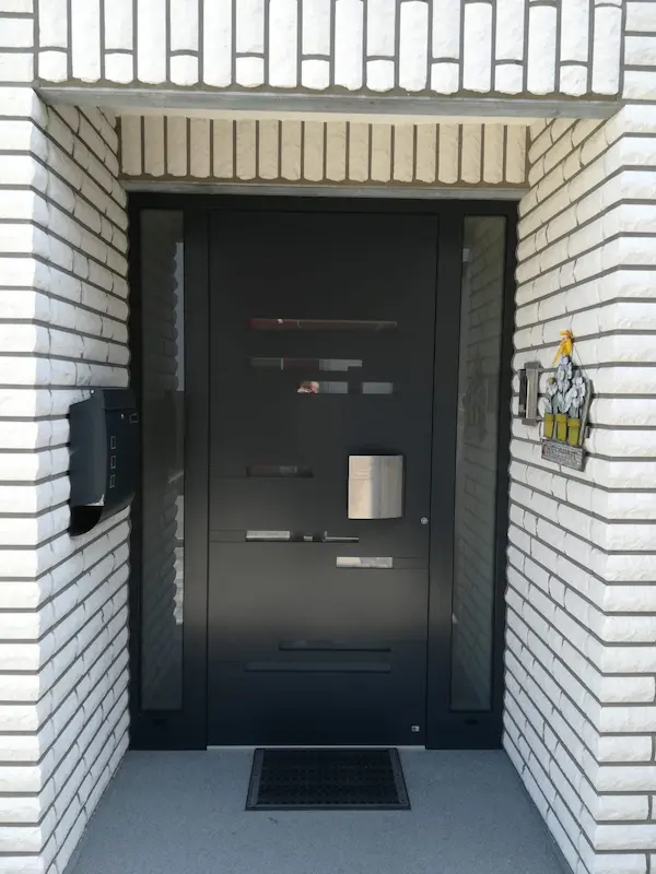 Neue Aluminium-Eingangstür in Anthrazit mit Seitenteilen an einem Haus in Eschweiler